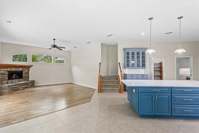 a view of an empty room with wooden floor fireplace and a window