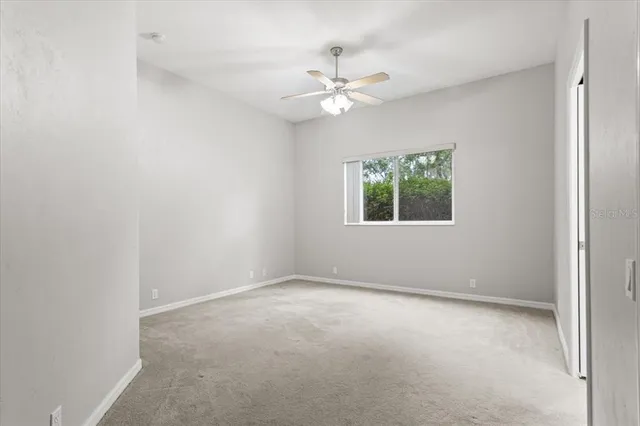 an empty room with closet and a chandelier fan