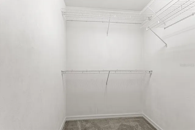 an empty room with windows and ceiling fan