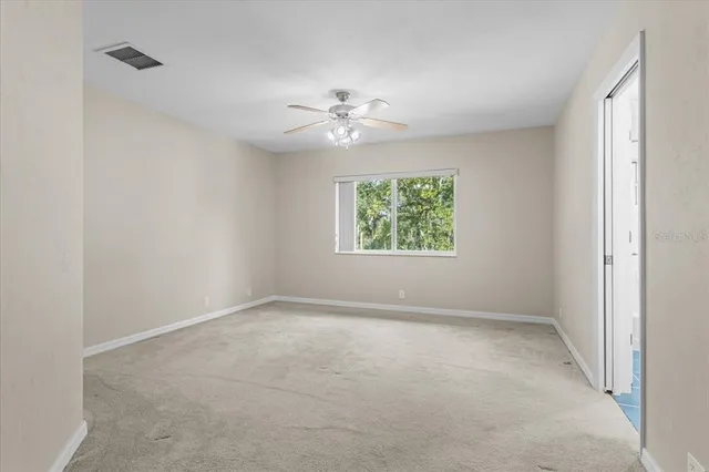 an empty room with an entryway and fan