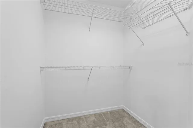 an empty room with an entryway and fan