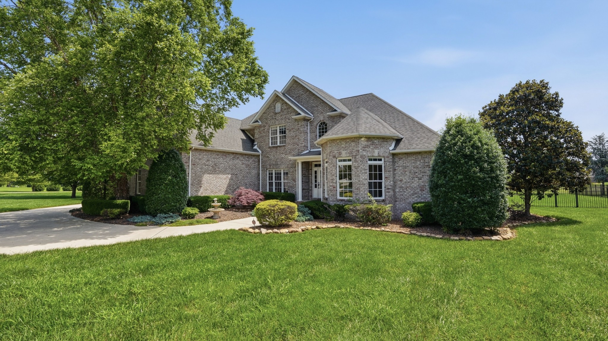 a front view of a house with a yard and trees