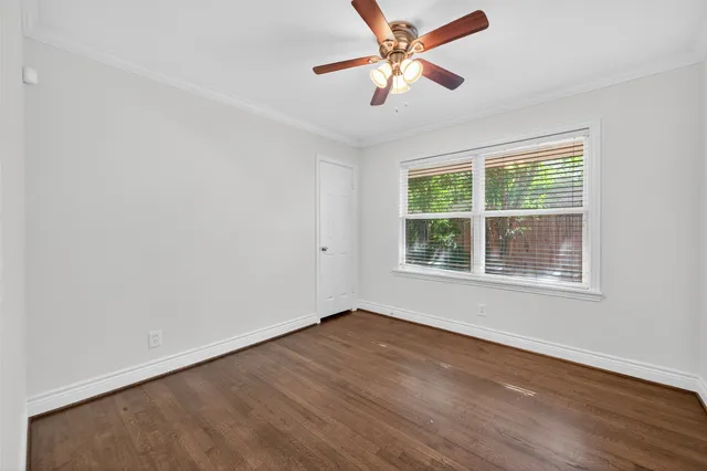 a view of a big room with wooden floor and windows
