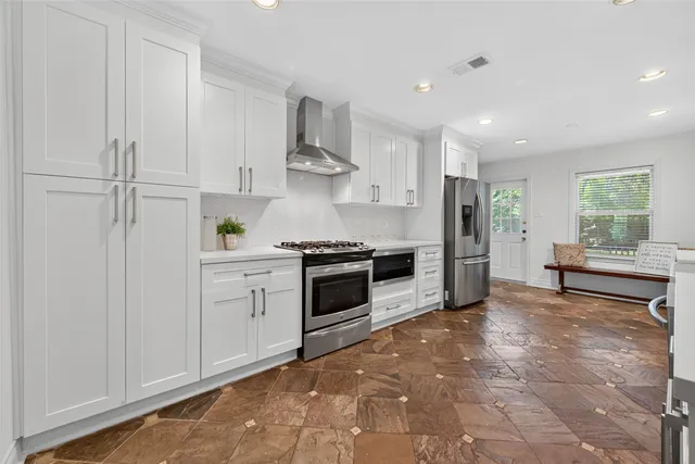 a large white kitchen with cabinets