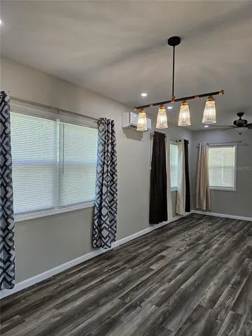 a view of a room with a ceiling fan and window