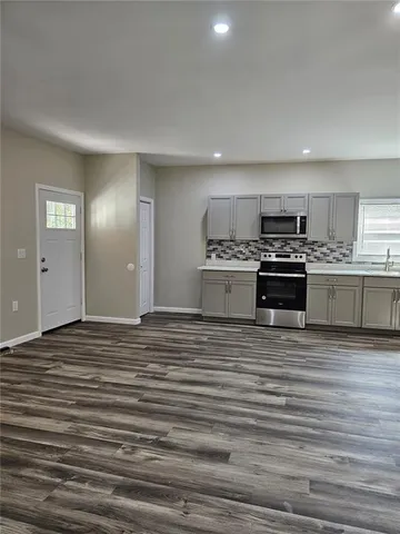 a view of a kitchen with stainless steel appliances granite countertop a stove and a sink