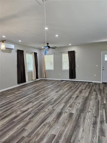 a view of a livingroom with a ceiling fan and wooden floor