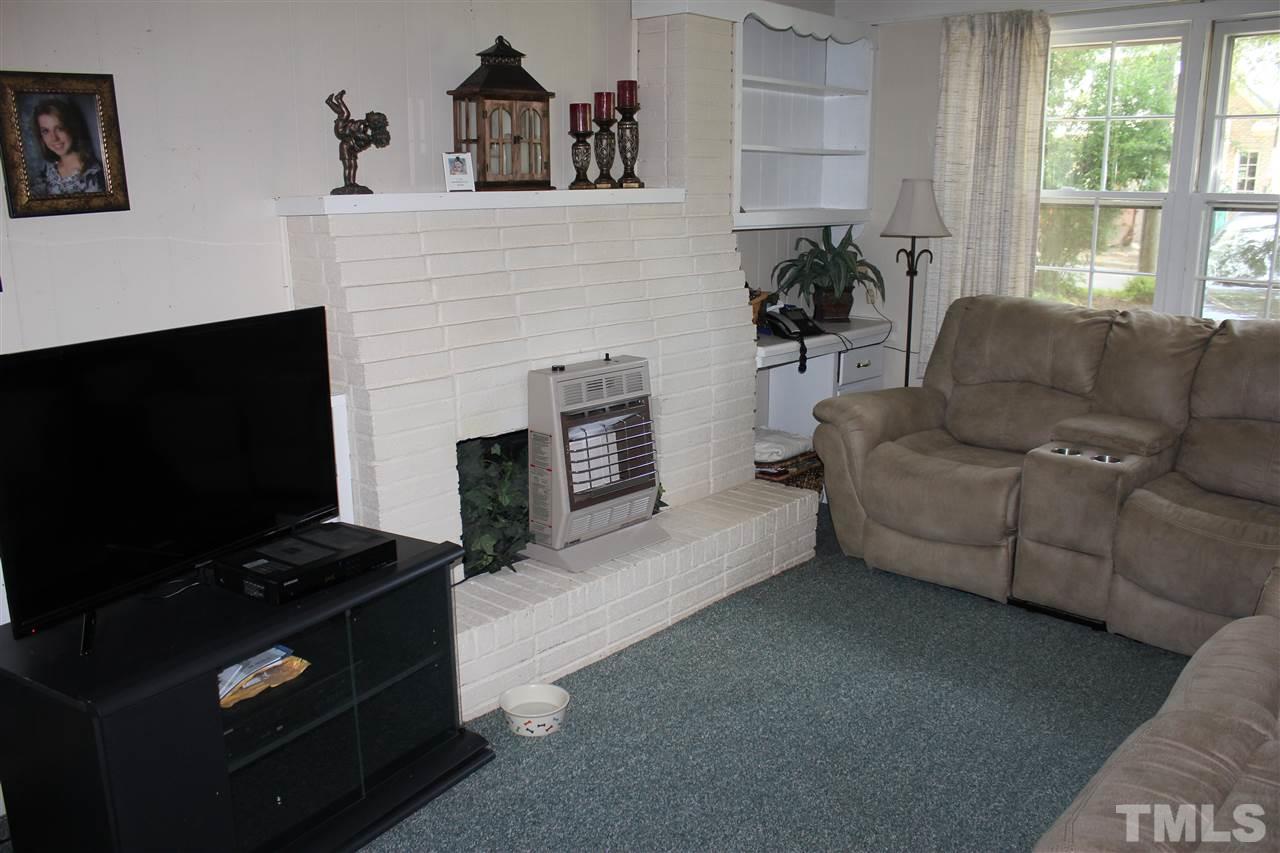 816 Macon Place Raleigh, NC 27609 - Photo 3 of 17 a living room with furniture a flat screen tv and a fireplace