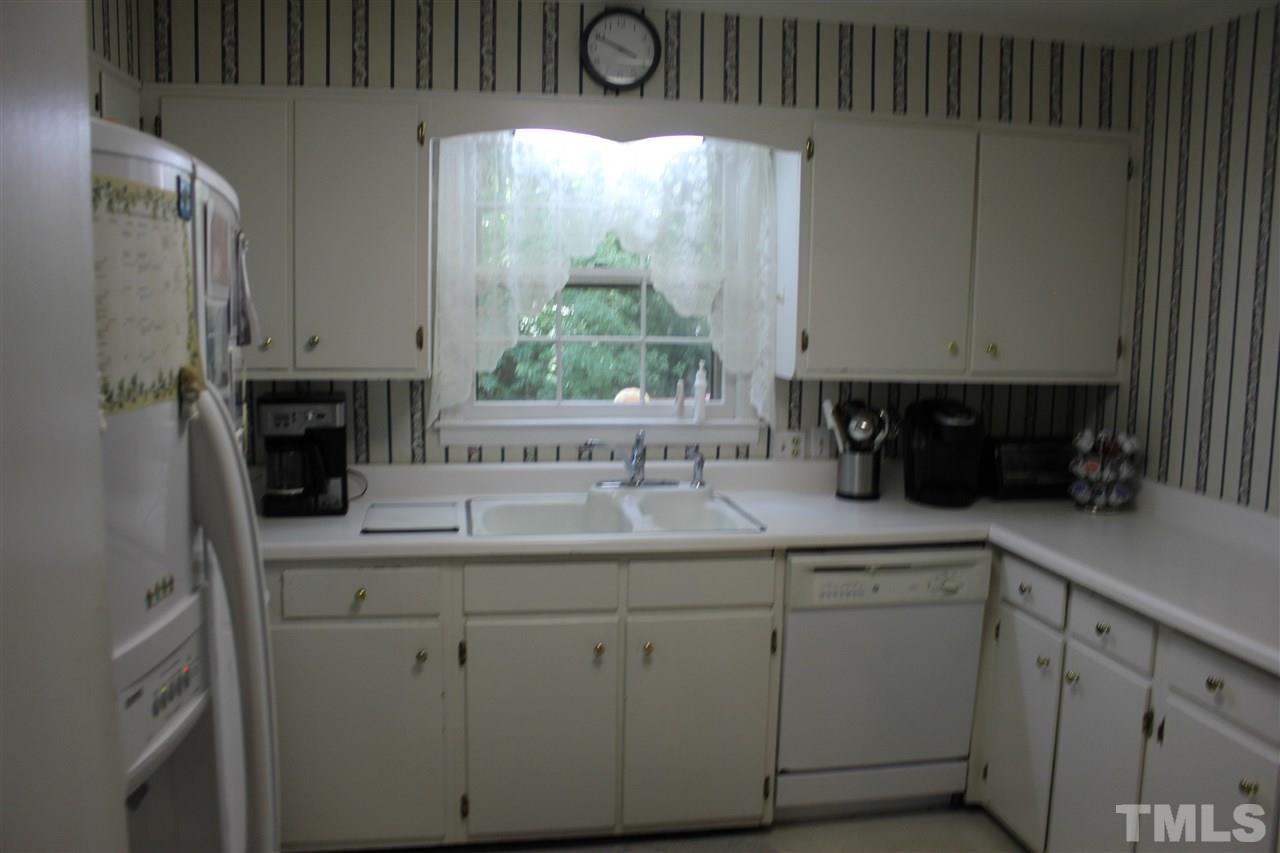 816 Macon Place Raleigh, NC 27609 - Photo 7 of 17 a kitchen with white cabinets and a window