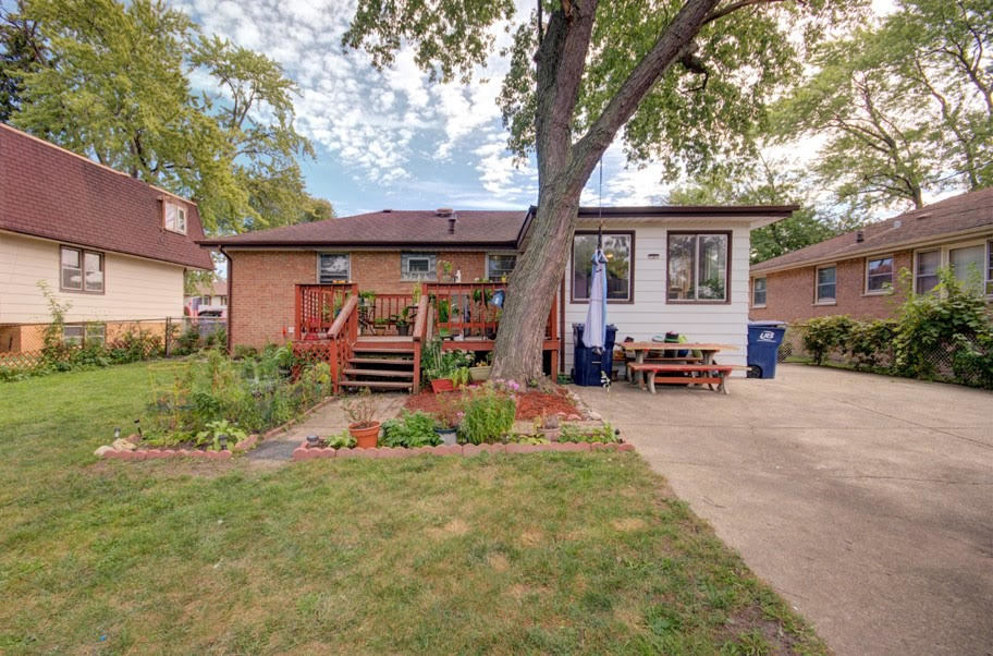 10828 Rutherford Avenue Worth, IL 60482 - Photo 23 of 25 a front view of a house with a yard and a large tree
