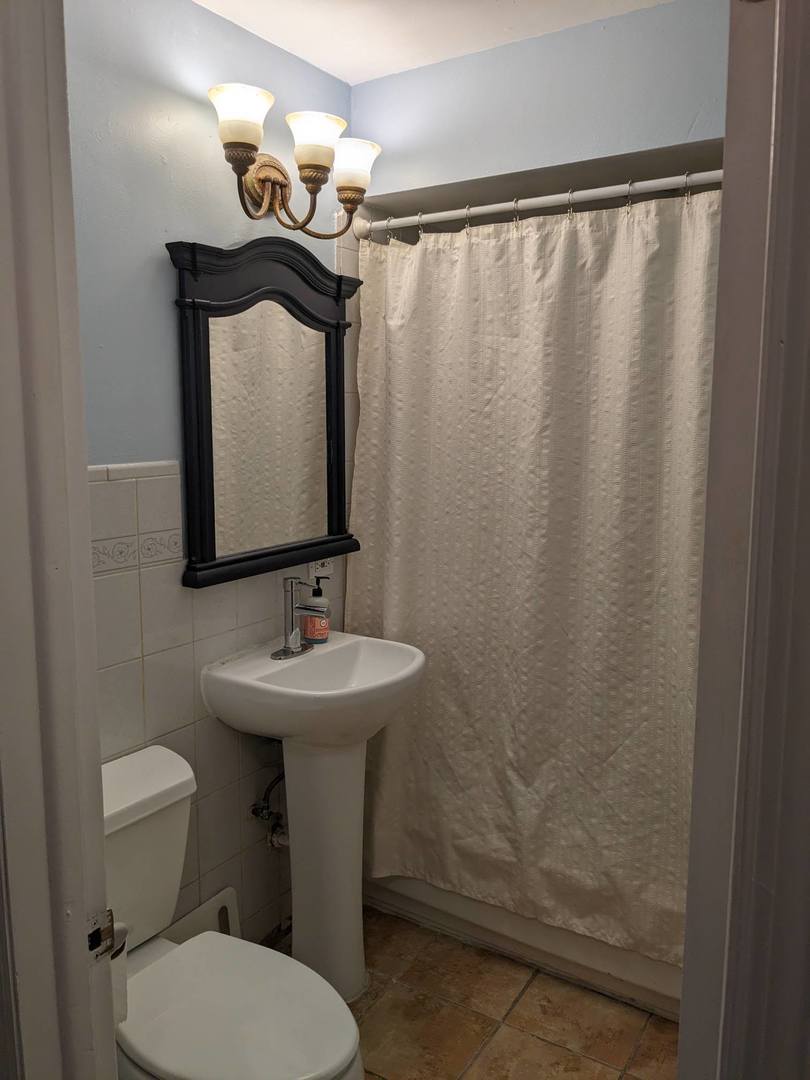 10828 Rutherford Avenue Worth, IL 60482 - Photo 10 of 25 a bathroom with a toilet a sink and mirror
