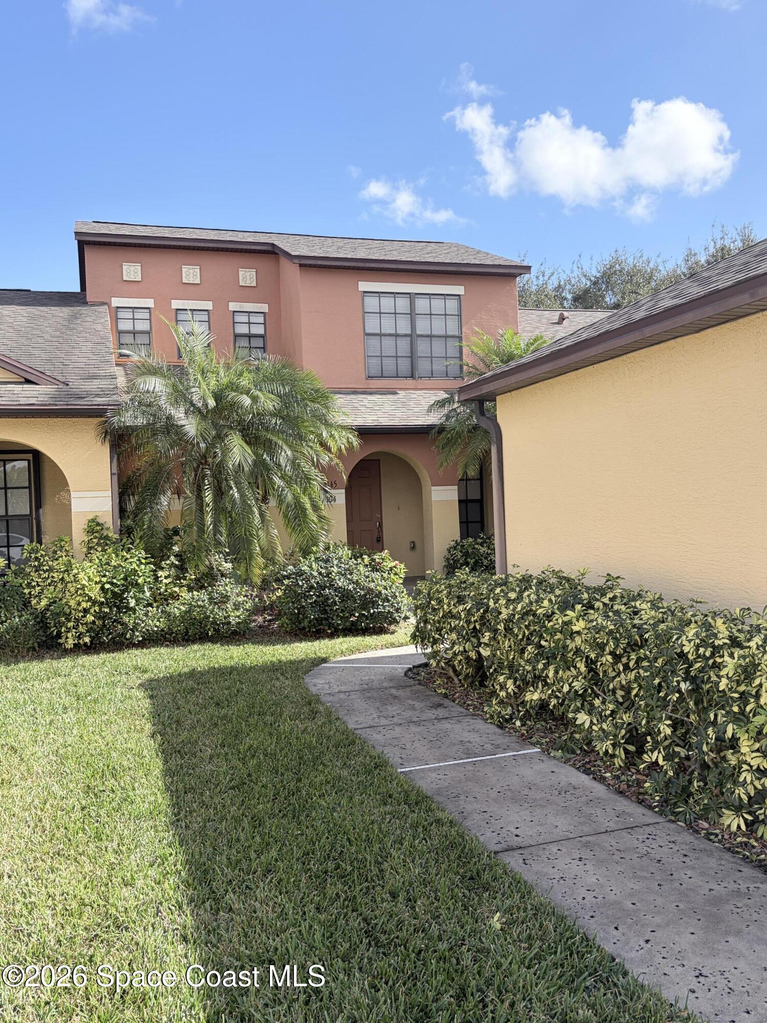 1145 Luminary Circle, Unit 104 Melbourne, FL 32901 - Photo 1 of 37 a front view of a house with a garden and yard