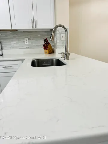 a kitchen with a sink a stove and cabinets