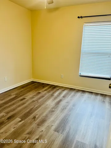 a view of a room with wooden floor and a window
