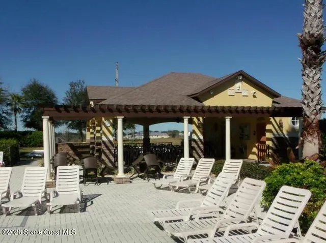 a view of a patio with a table and chairs under an umbrella with potted plants