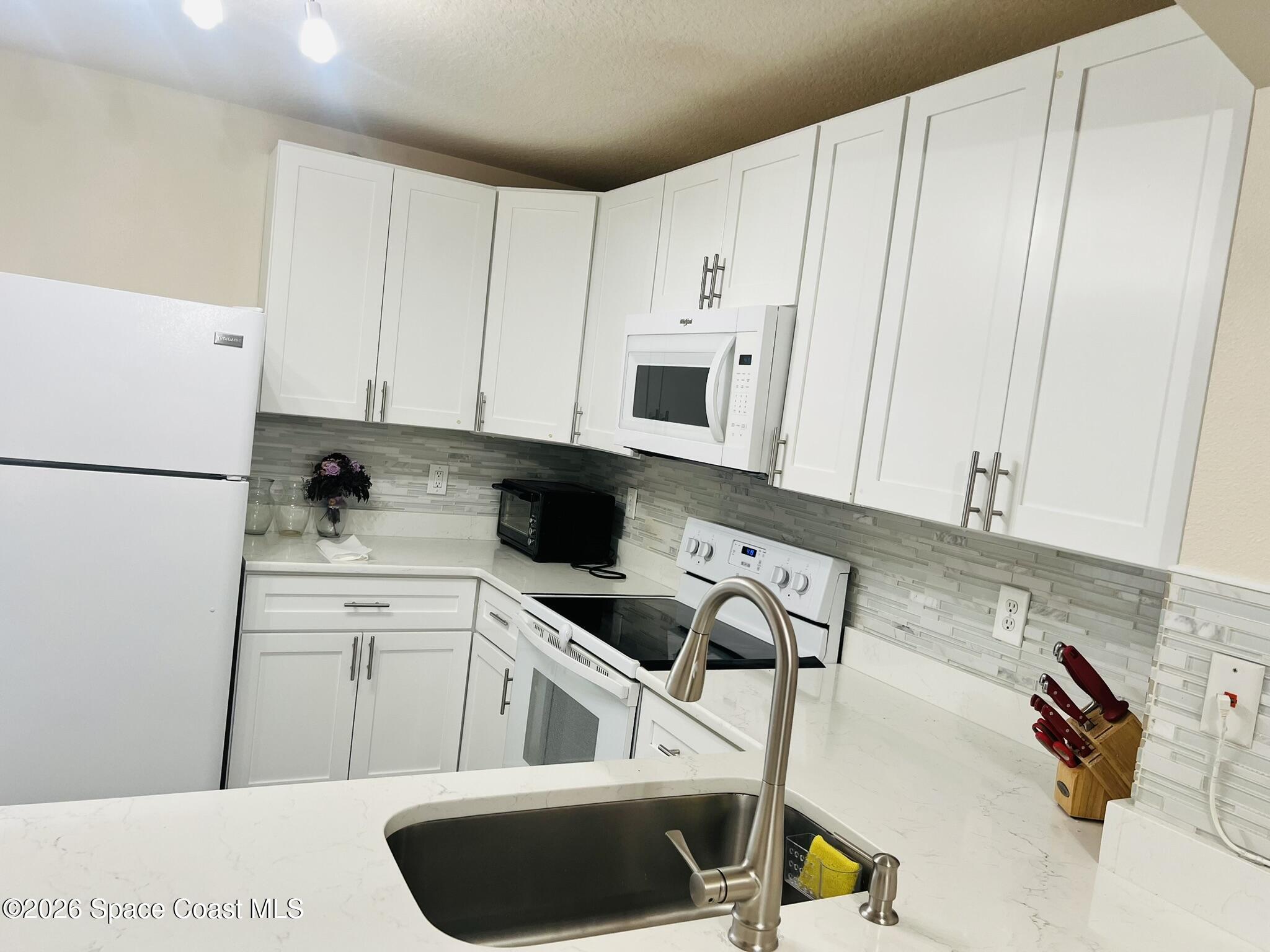 1145 Luminary Circle, Unit 104 Melbourne, FL 32901 - Photo 9 of 37 a kitchen with cabinets and appliances