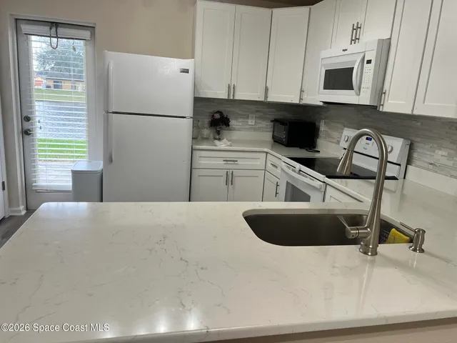 a kitchen with a refrigerator and a sink