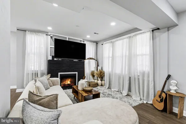 a living room with furniture a fireplace and a flat screen tv