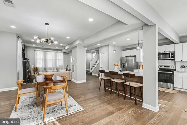 a living room with furniture a fireplace and chandelier