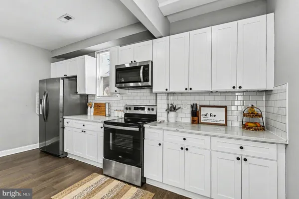 a kitchen with cabinets stainless steel appliances and a counter space