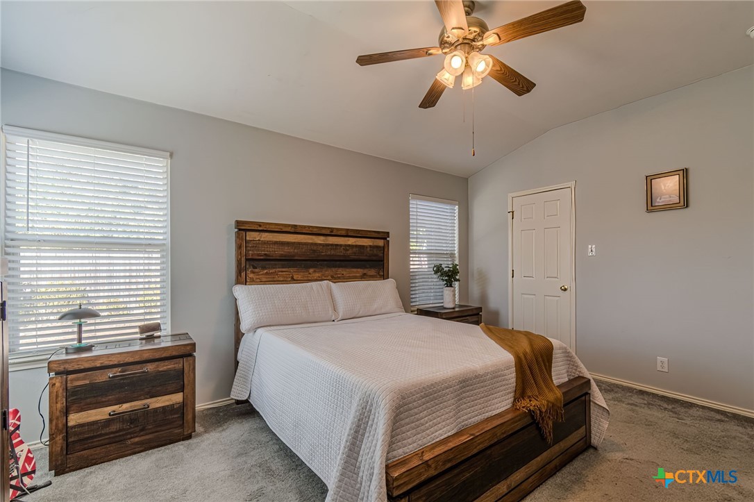 2369 Carson Loop New Braunfels, TX 78130 - Photo 11 of 28 a bedroom with a bed and a chandelier