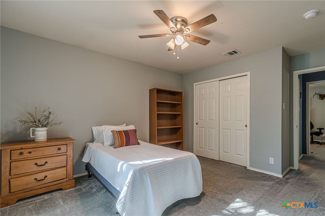2369 Carson Loop New Braunfels, TX 78130 - Photo 15 of 28 a bedroom with a bed and a chandelier
