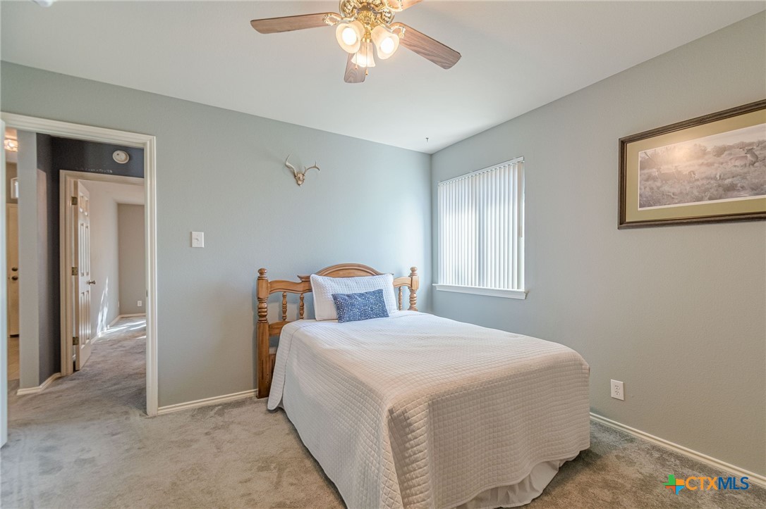 2369 Carson Loop New Braunfels, TX 78130 - Photo 17 of 28 a bedroom with a bed and a chandelier