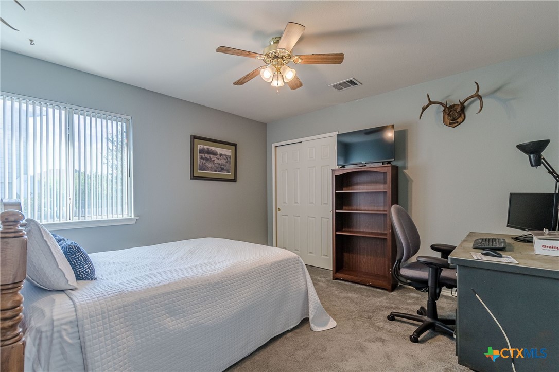 2369 Carson Loop New Braunfels, TX 78130 - Photo 18 of 28 a bedroom with a bed and a chandelier