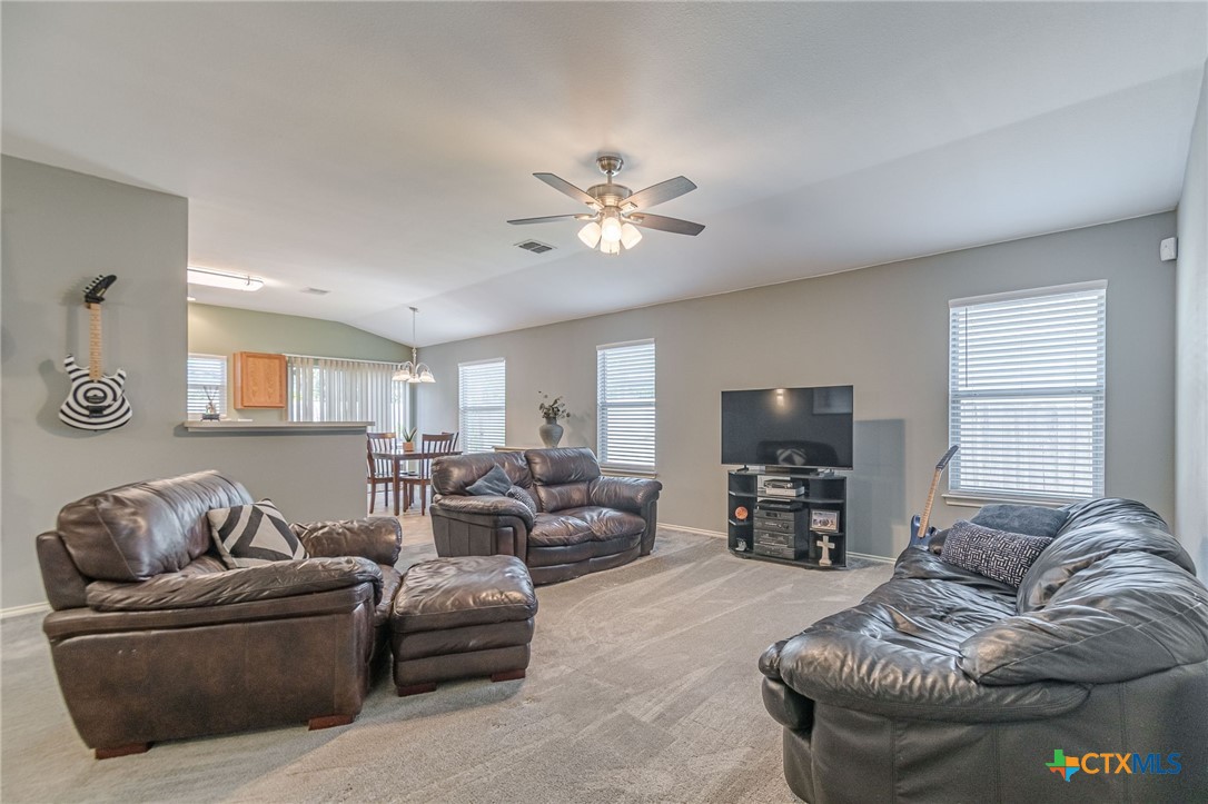 2369 Carson Loop New Braunfels, TX 78130 - Photo 2 of 28 a living room with furniture and a flat screen tv with kitchen view
