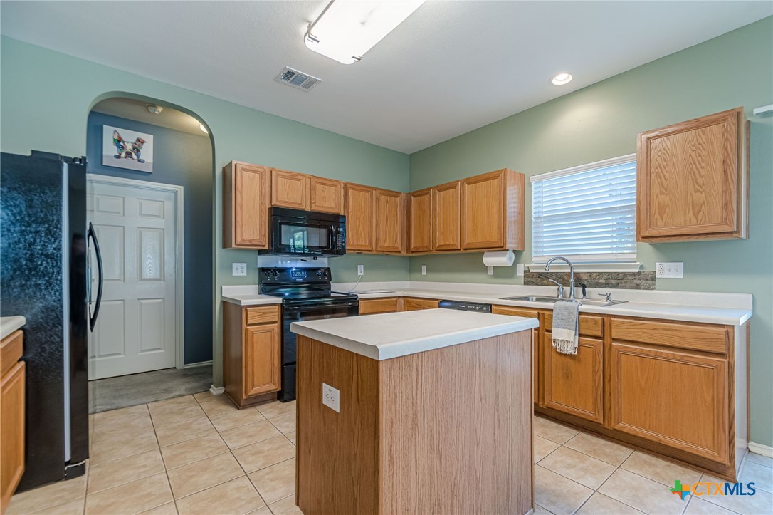 2369 Carson Loop New Braunfels, TX 78130 - Photo 5 of 28 a kitchen with stainless steel appliances granite countertop a stove top oven a refrigerator a sink and dishwasher