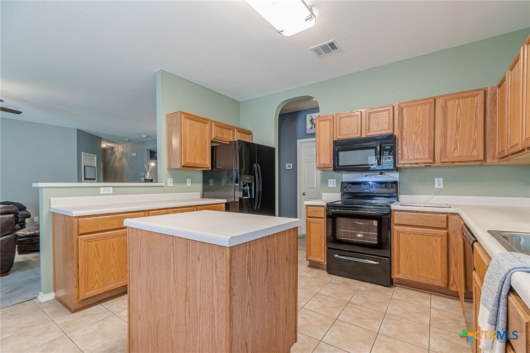 2369 Carson Loop New Braunfels, TX 78130 - Photo 6 of 28 a kitchen with stainless steel appliances a sink stove refrigerator and cabinets