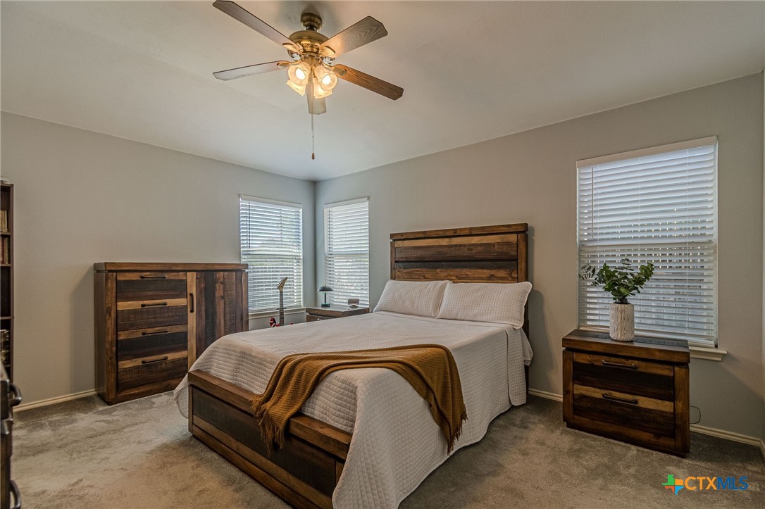 2369 Carson Loop New Braunfels, TX 78130 - Photo 9 of 28 a bedroom with a bed and a chandelier