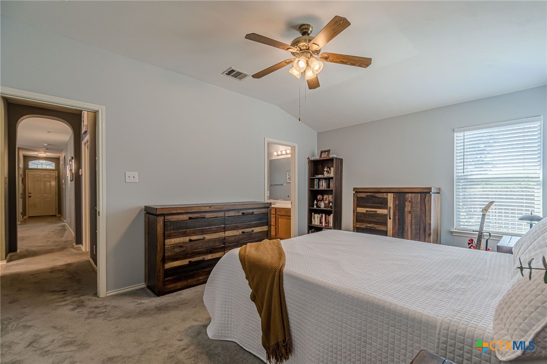 2369 Carson Loop New Braunfels, TX 78130 - Photo 10 of 28 a bedroom with a bed and a chandelier