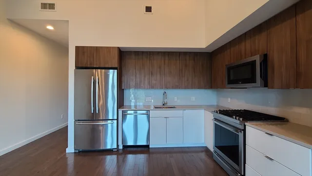 a kitchen with a sink a microwave a refrigerator and cabinets