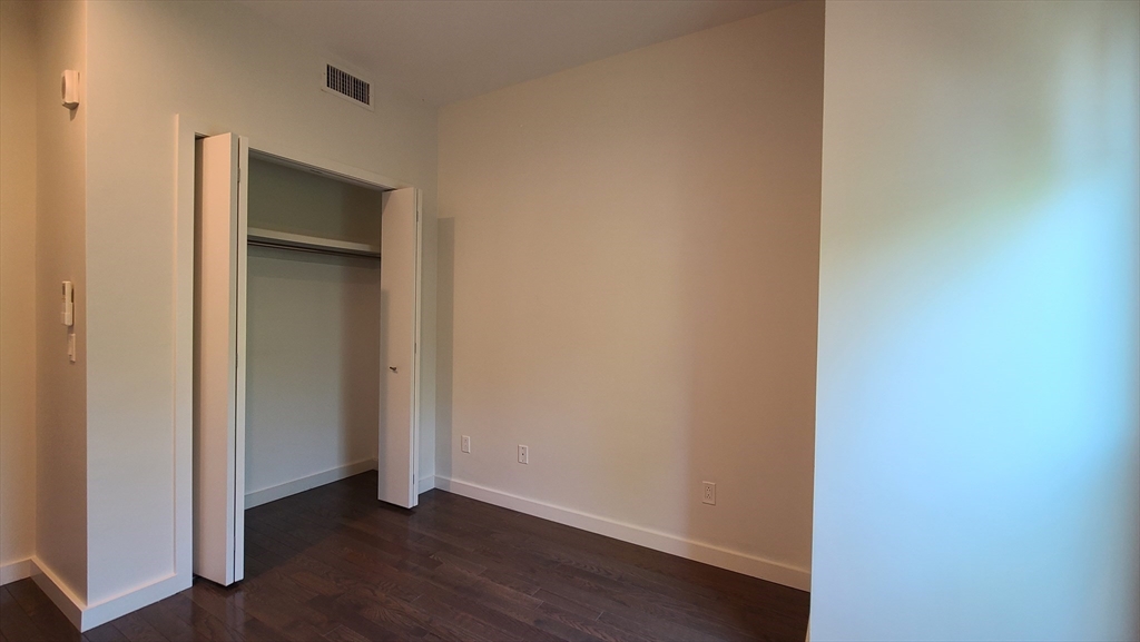 143-171 Hyde Park Avenue, Unit 163B Boston, MA 02130 - Photo 14 of 24 a view of an empty room with wooden floor and closet
