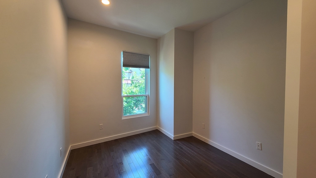 143-171 Hyde Park Avenue, Unit 163B Boston, MA 02130 - Photo 15 of 24 an empty room with wooden floor and windows