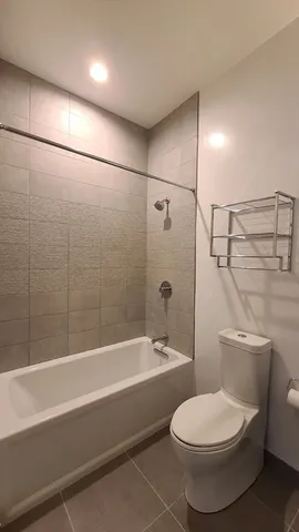 a bathroom with a toilet and a bath tub