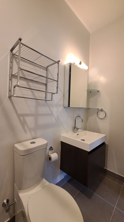 143-171 Hyde Park Avenue, Unit 163B Boston, MA 02130 - Photo 19 of 24 a bathroom with a sink toilet and mirror