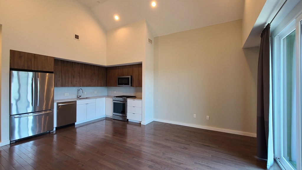 143-171 Hyde Park Avenue, Unit 163B Boston, MA 02130 - Photo 9 of 24 a kitchen with stainless steel appliances granite countertop a refrigerator and a stove top oven