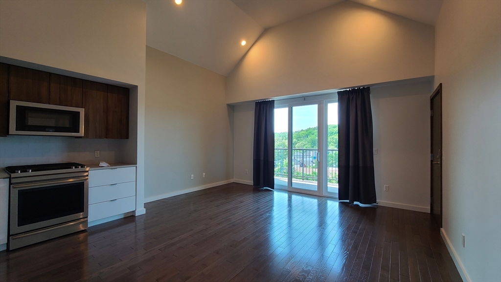 143-171 Hyde Park Avenue, Unit 163B Boston, MA 02130 - Photo 10 of 24 an empty room with wooden floor and windows