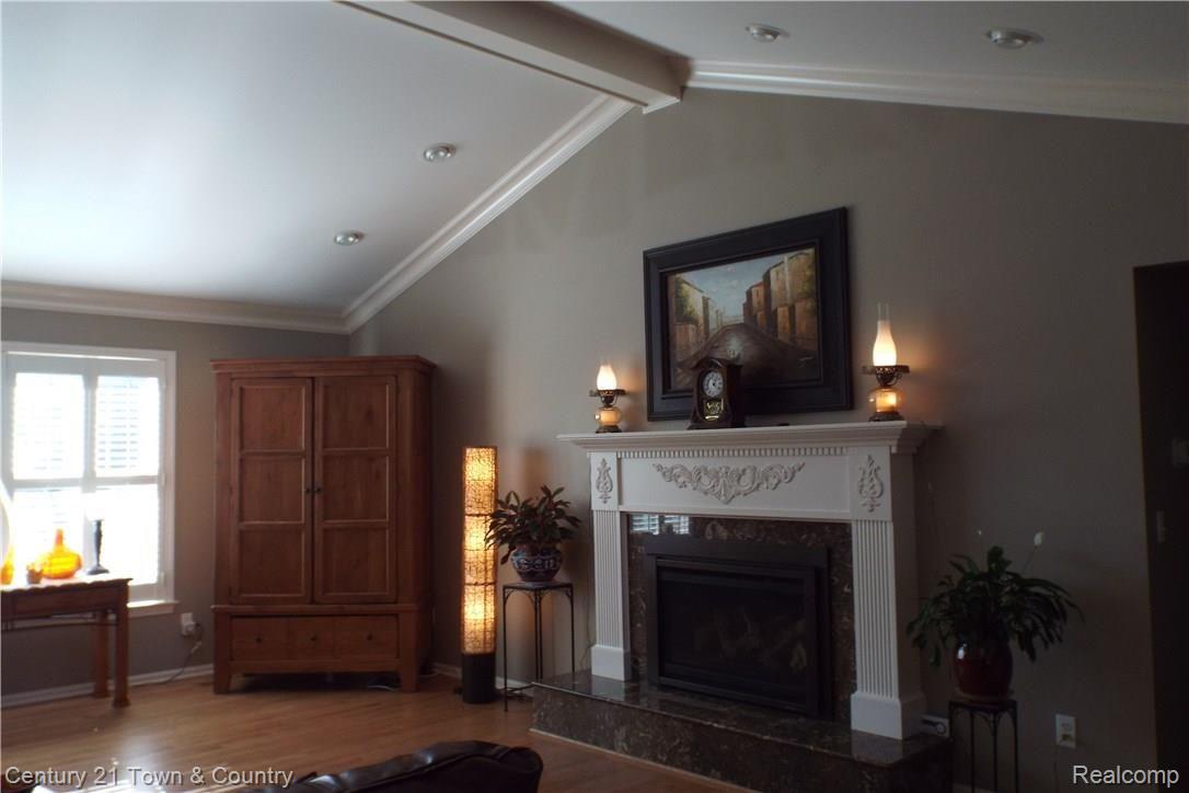 6384 Perry Road Grand Blanc, MI 48439 - Photo 11 of 77 Large fire-lit 30 x 14 family room with vaulted ceilings. Warm lighting to make family gatherings feel cozy.