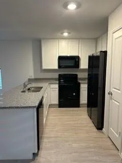 a kitchen with stainless steel appliances granite countertop a refrigerator and a stove top oven