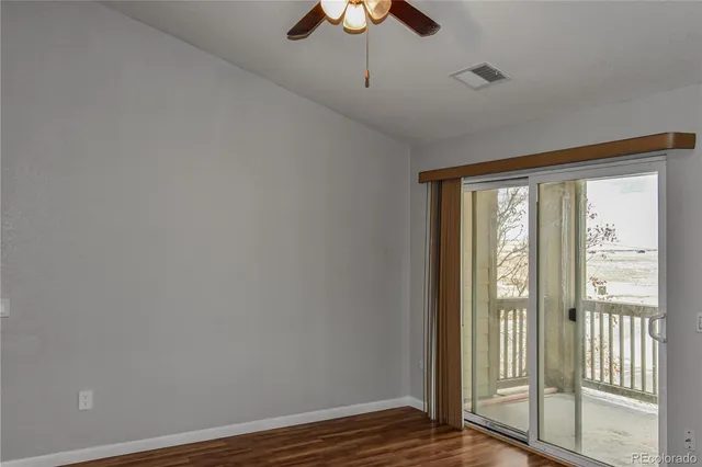 a view of an empty room with a window and a ceiling fan