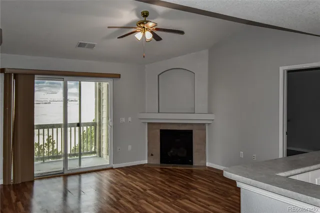 a view of empty room with fireplace and wooden floor