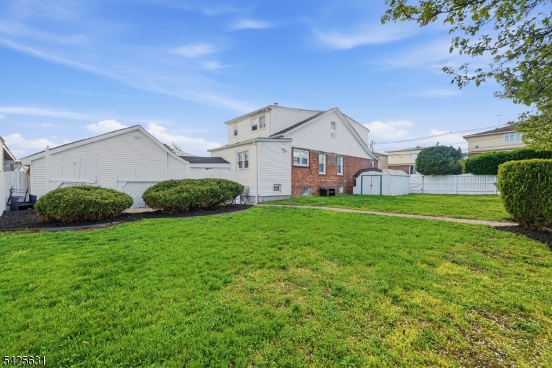 60 Westervelt Place Lodi, NJ 07644 - Photo 39 of 48 a view of a house with a big yard potted plants and large tree