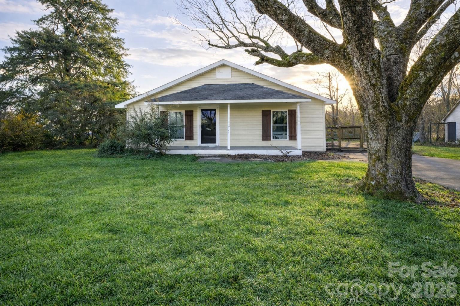 a front view of a house with a garden and trees