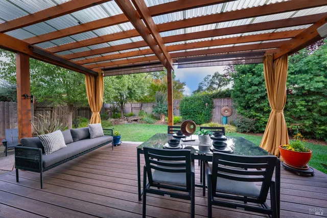 a view of a patio with couches plants and wooden floor