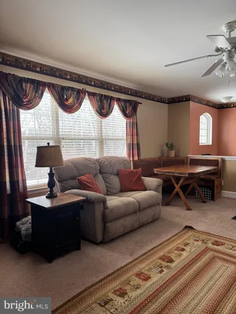 a living room with furniture a table and a large window