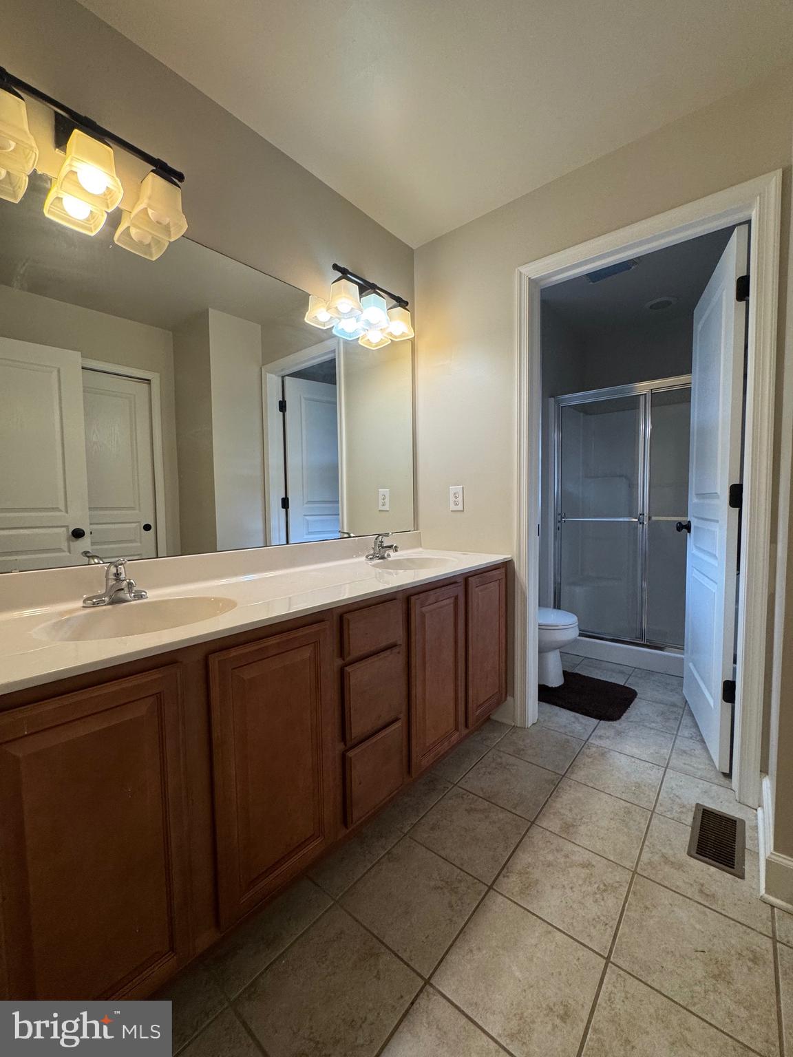 5432 Lake Road Newfield, NJ 08344 - Photo 13 of 24 a spacious bathroom with a double vanity sink a toilet and a mirror