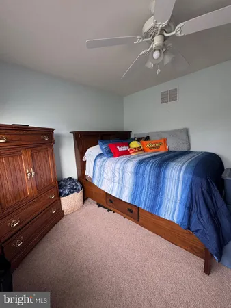 a blue bed sitting in a room next to a lamp